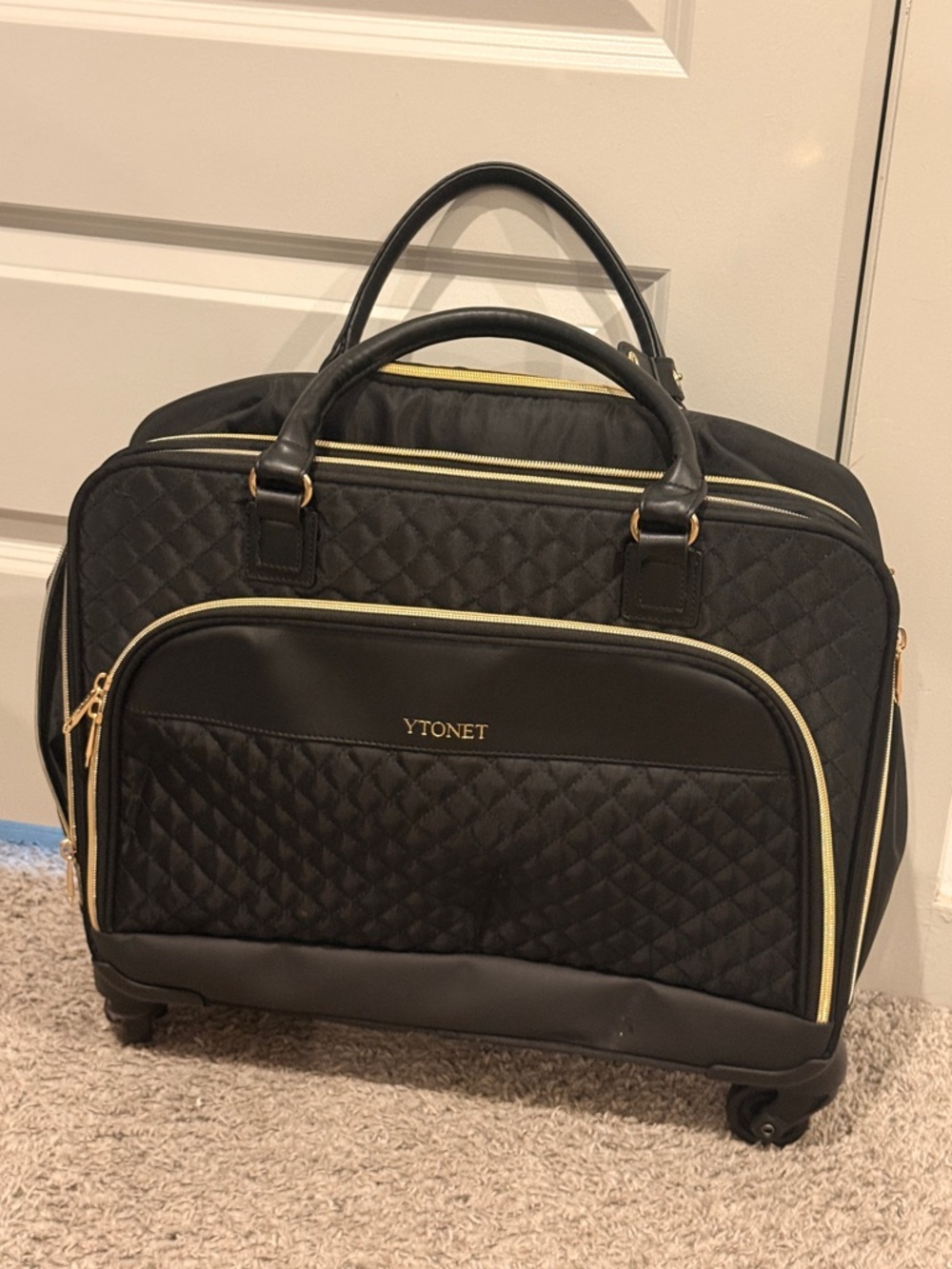 Black Quilted Rolling Travel Bag with Gold Accents